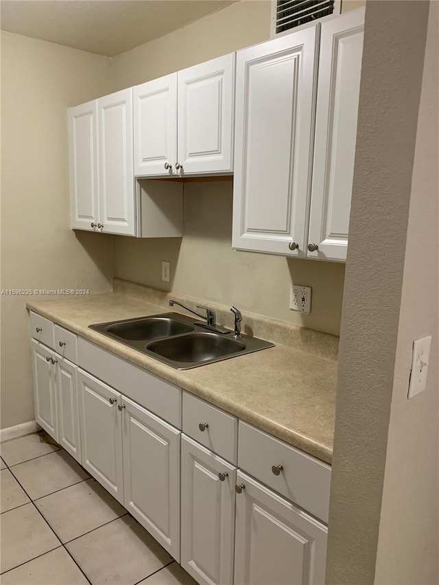 kitchen featuring sink, white cabinets, and light tile patterned floors