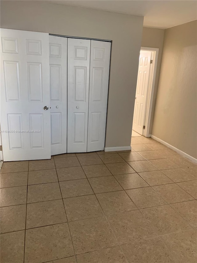 unfurnished bedroom featuring tile patterned floors and a closet