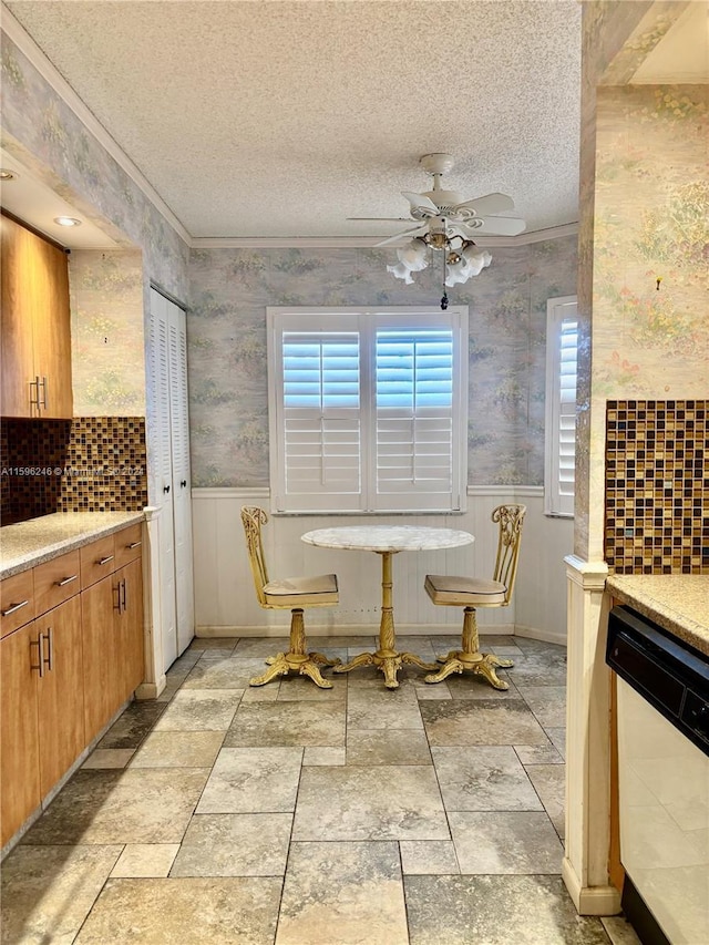 dining room featuring a textured ceiling, ceiling fan, and crown molding