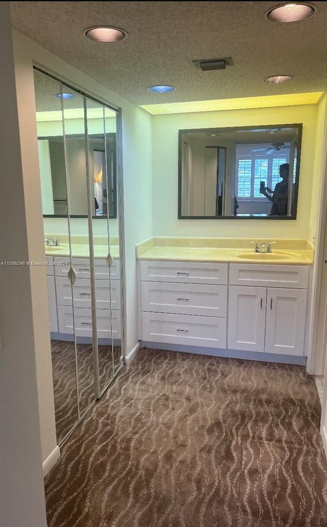 bathroom featuring a textured ceiling and sink