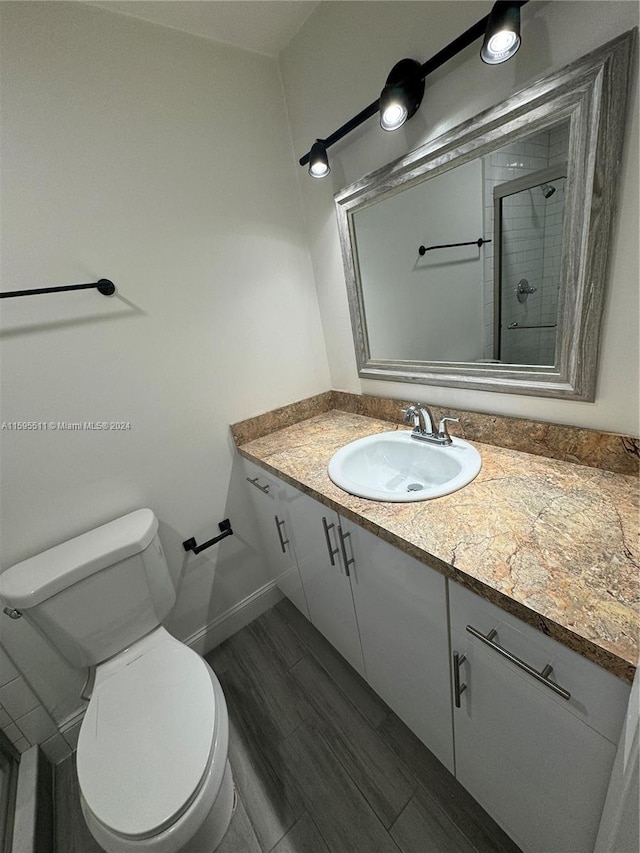 bathroom featuring vanity, toilet, and a shower with shower door