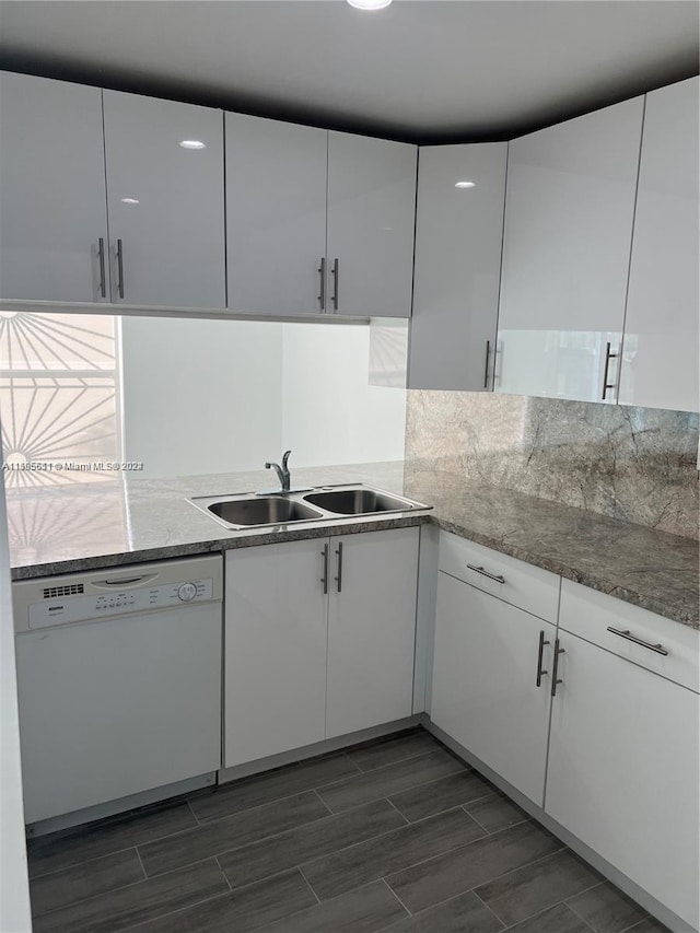 kitchen featuring light stone countertops, white dishwasher, white cabinetry, and sink