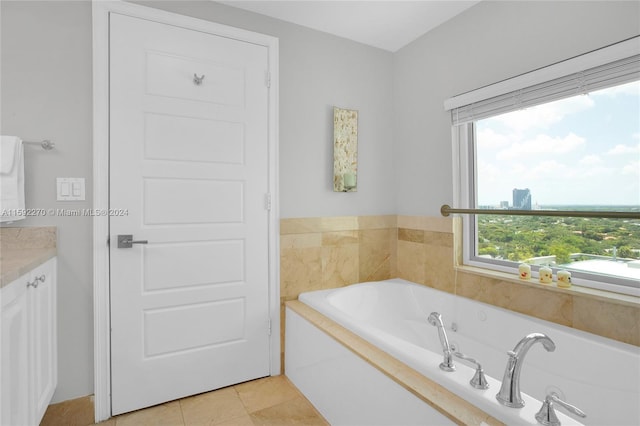 bathroom with vanity, a relaxing tiled tub, and tile patterned floors