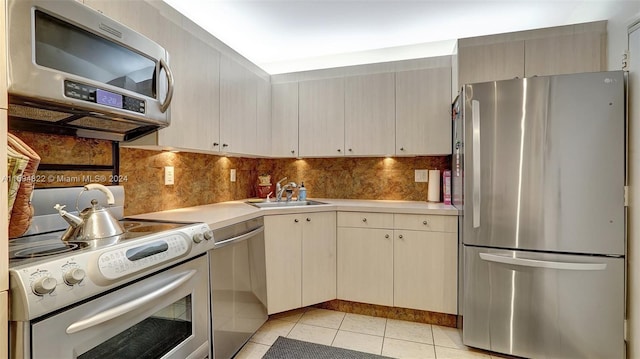 kitchen with sink, stainless steel appliances, light tile patterned flooring, and decorative backsplash