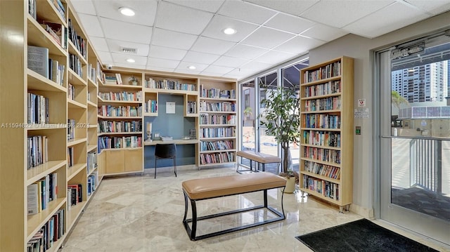 living area with a drop ceiling