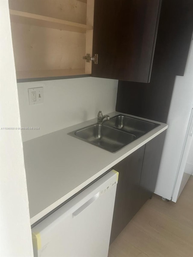 kitchen featuring dishwasher, sink, and light hardwood / wood-style flooring