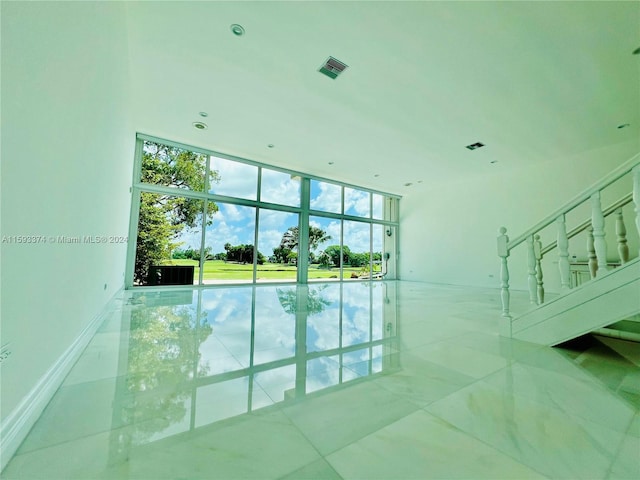 tiled spare room with a wall of windows