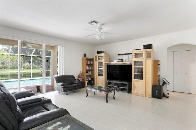 living room with light tile patterned flooring, a textured ceiling, and ceiling fan