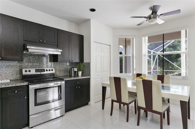 kitchen featuring stainless steel electric stove, light stone countertops, decorative backsplash, and exhaust hood