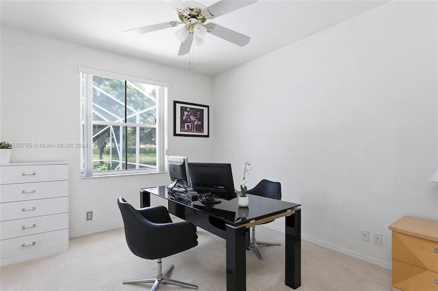 carpeted home office featuring ceiling fan