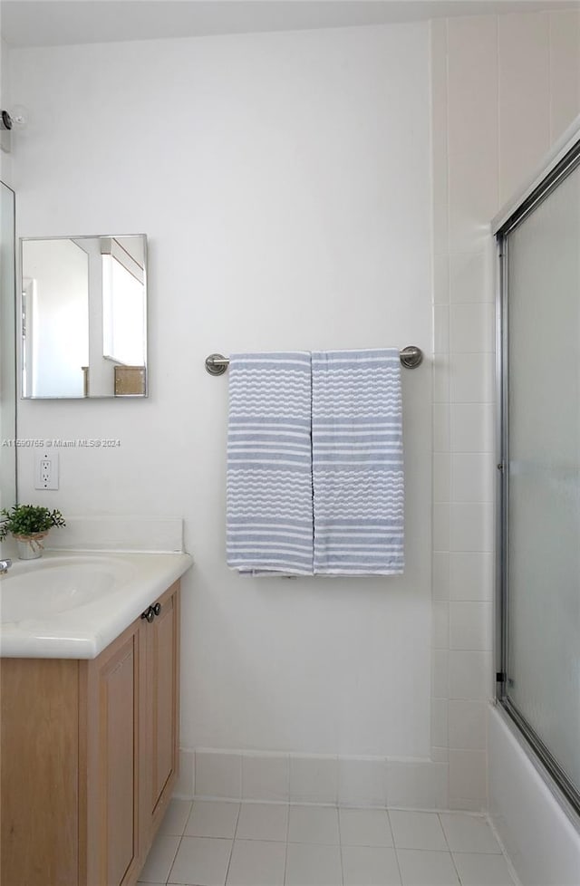 bathroom with tile patterned floors, vanity, and shower / bath combination with glass door