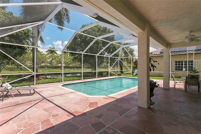 view of swimming pool with a patio, a lanai, and ceiling fan