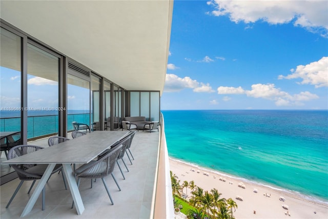 balcony featuring a view of the beach and a water view