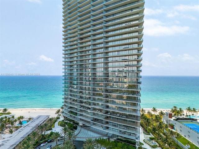 view of building exterior with a view of the beach and a water view