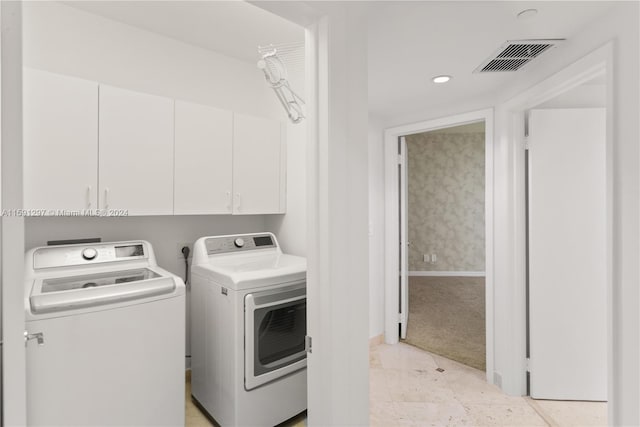 laundry area with cabinets, light colored carpet, and separate washer and dryer