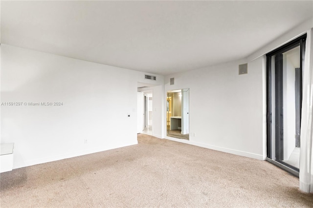 spare room featuring light colored carpet