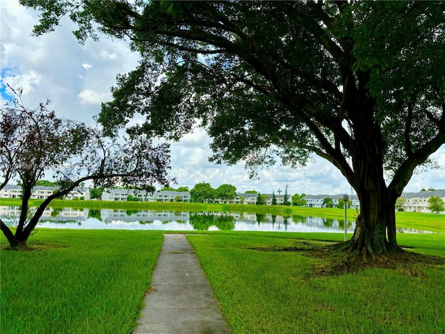 view of community with a lawn and a water view