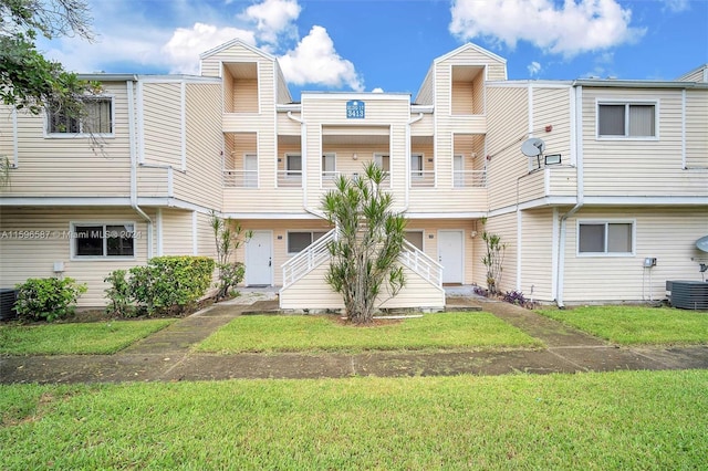 view of front facade with central AC unit and a front yard