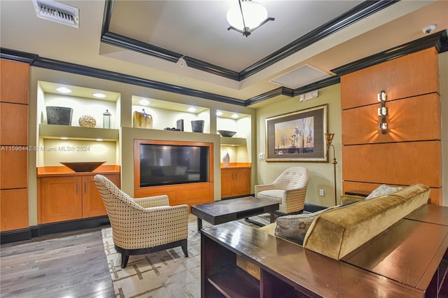 living room with light hardwood / wood-style flooring, a raised ceiling, and crown molding