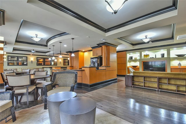 living room featuring hardwood / wood-style floors, a tray ceiling, and crown molding