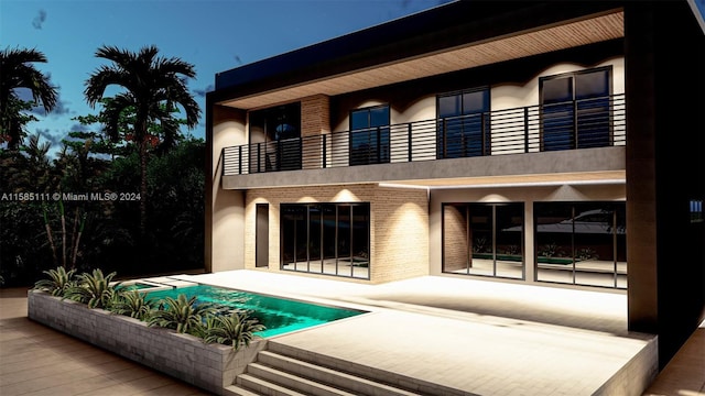 rear view of house with a patio and a balcony