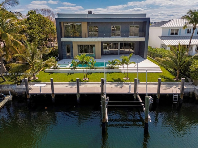 back of property featuring a lawn, a swimming pool, a patio area, and a water view