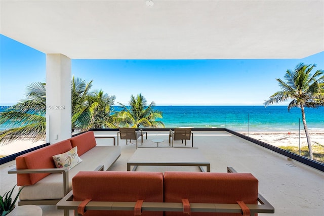 view of terrace with outdoor lounge area, a beach view, and a water view