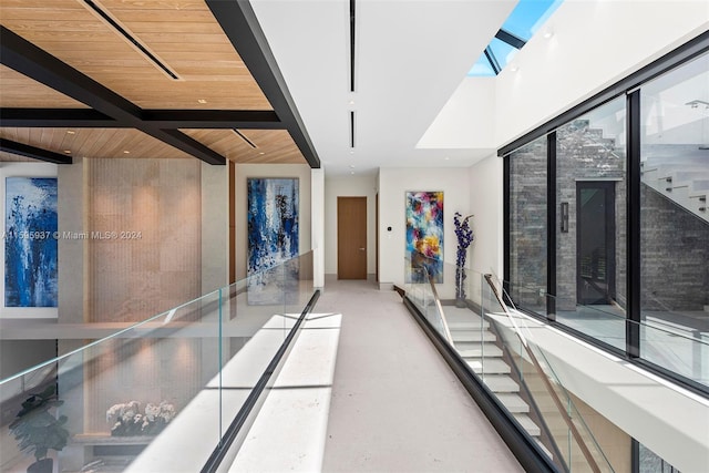 interior space with beamed ceiling, wooden ceiling, and a skylight