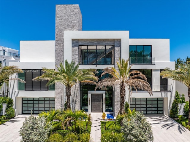 contemporary house with a garage and a balcony