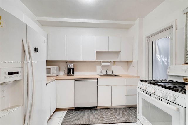 kitchen with white cabinetry, sink, light tile patterned floors, and white appliances