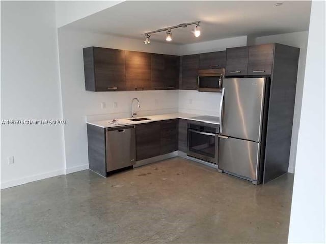 kitchen featuring dark brown cabinets, stainless steel appliances, concrete floors, and rail lighting