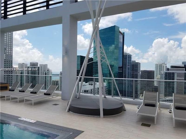 view of patio / terrace featuring a community pool and a balcony