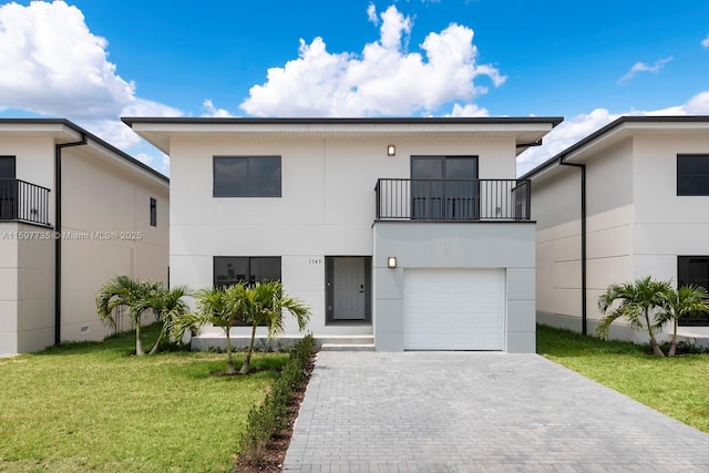 view of front facade with a balcony, stucco siding, a front lawn, a garage, and decorative driveway