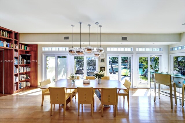 dining space with a healthy amount of sunlight, built in shelves, and hardwood / wood-style floors