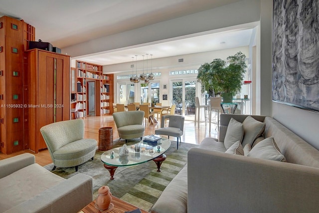 living room featuring a notable chandelier and light hardwood / wood-style flooring