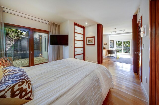 bedroom featuring french doors, hardwood / wood-style floors, and access to outside