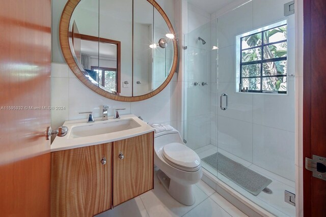 bathroom featuring tile floors, an enclosed shower, vanity, and toilet