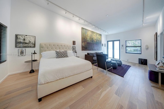 bedroom featuring light hardwood / wood-style flooring and rail lighting