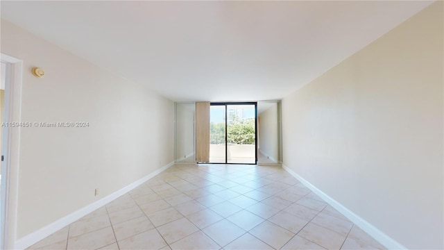 tiled spare room featuring expansive windows