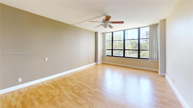 spare room with ceiling fan and light wood-type flooring