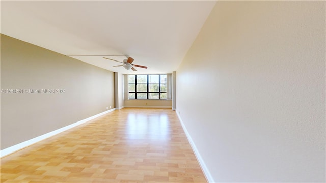 empty room with ceiling fan, lofted ceiling, and light hardwood / wood-style flooring