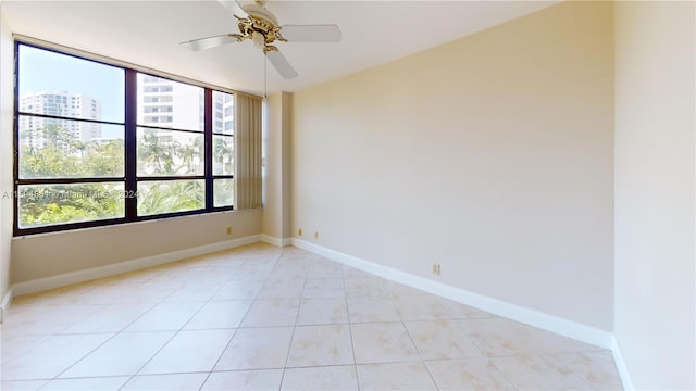 spare room with ceiling fan and light tile patterned flooring