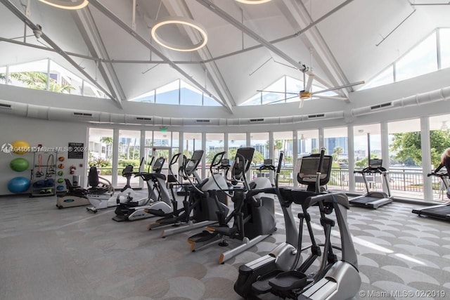 exercise room with carpet floors, ceiling fan, and high vaulted ceiling