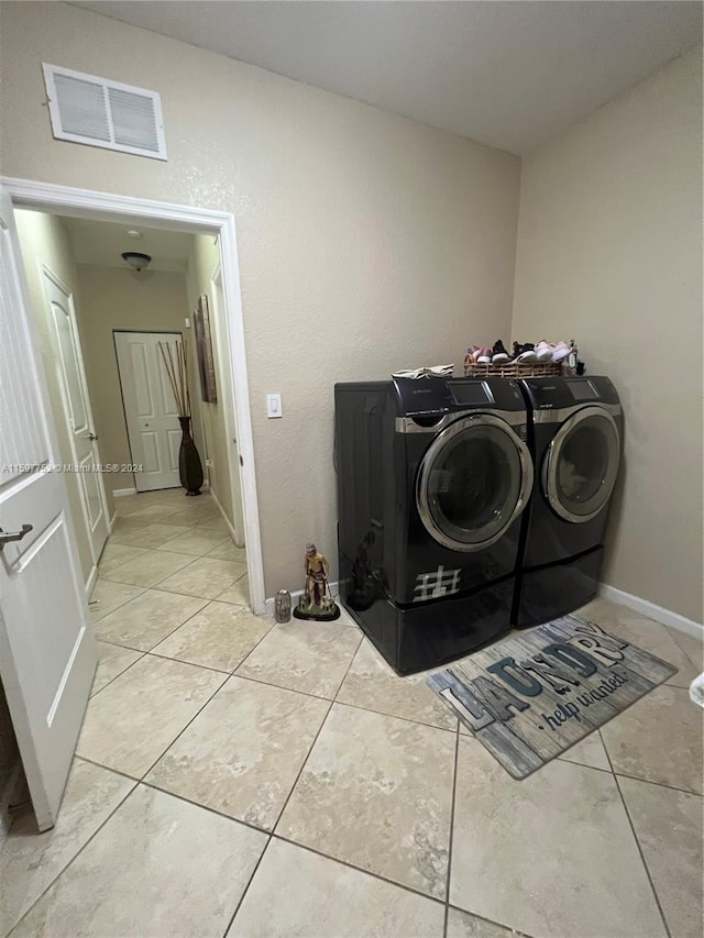 washroom featuring washer and clothes dryer and light tile patterned floors