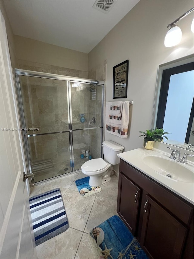 bathroom featuring tile patterned floors, walk in shower, vanity, and toilet