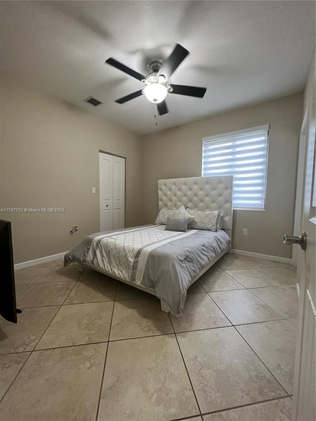 tiled bedroom featuring a closet and ceiling fan