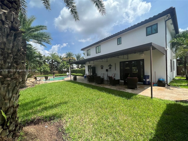 back of property featuring outdoor lounge area, a patio, and a lawn