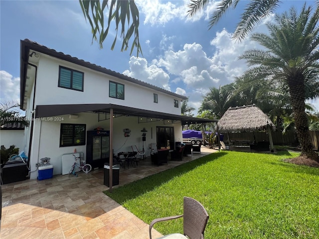 back of house with a gazebo, a patio area, a lawn, and an outdoor hangout area