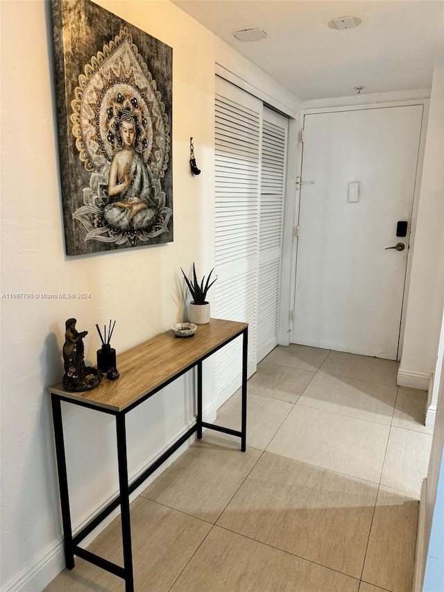 doorway with light tile patterned flooring