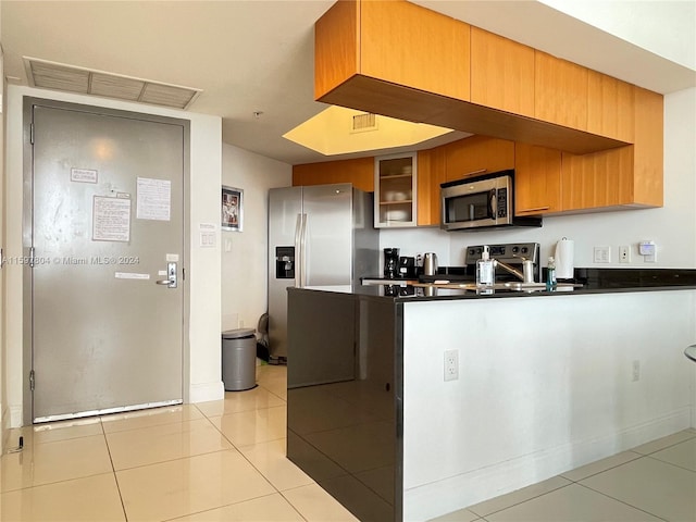 kitchen with kitchen peninsula, light tile floors, and appliances with stainless steel finishes